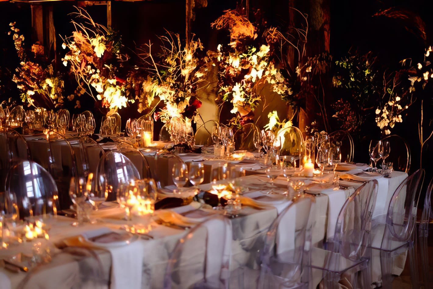 A dinner table set up with candles, flowers, and Victorian Ghost Chair Hire.