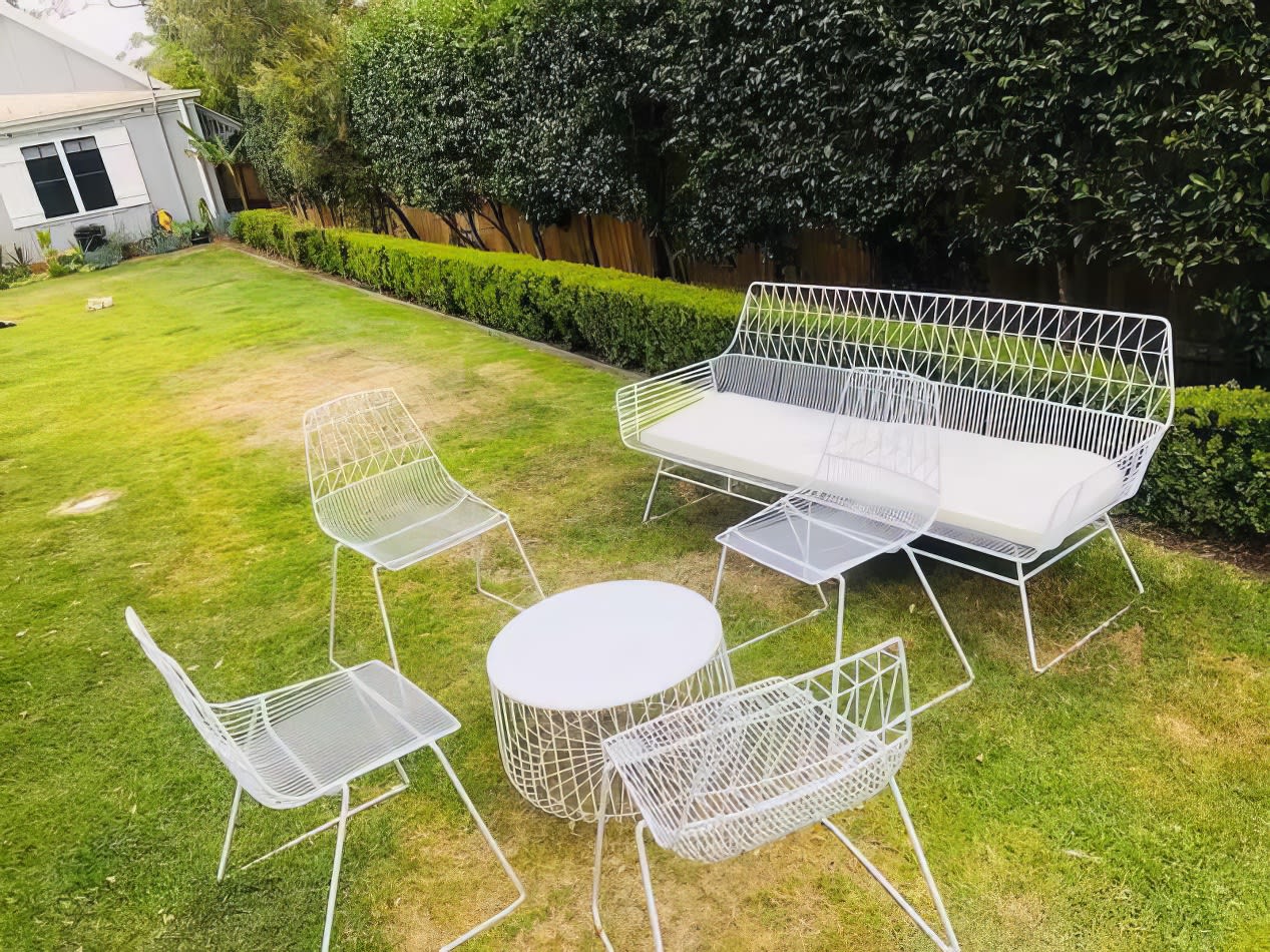 A white patio set with a table and chairs available for hire.