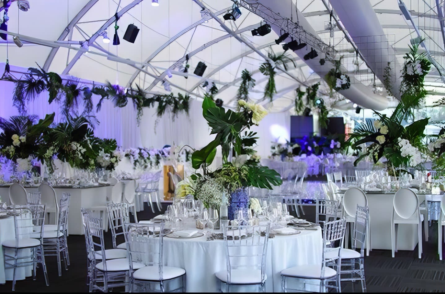 A large tent with Clear Tiffany Chair Hire set up on white tables.