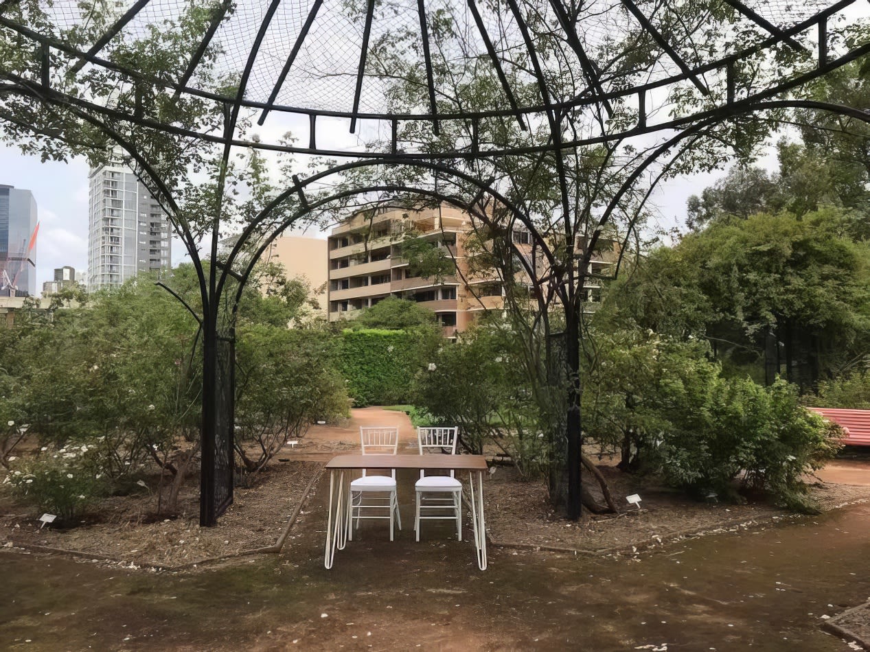 A garden gazebo with a table and chairs set in the middle, available for signing table hire.