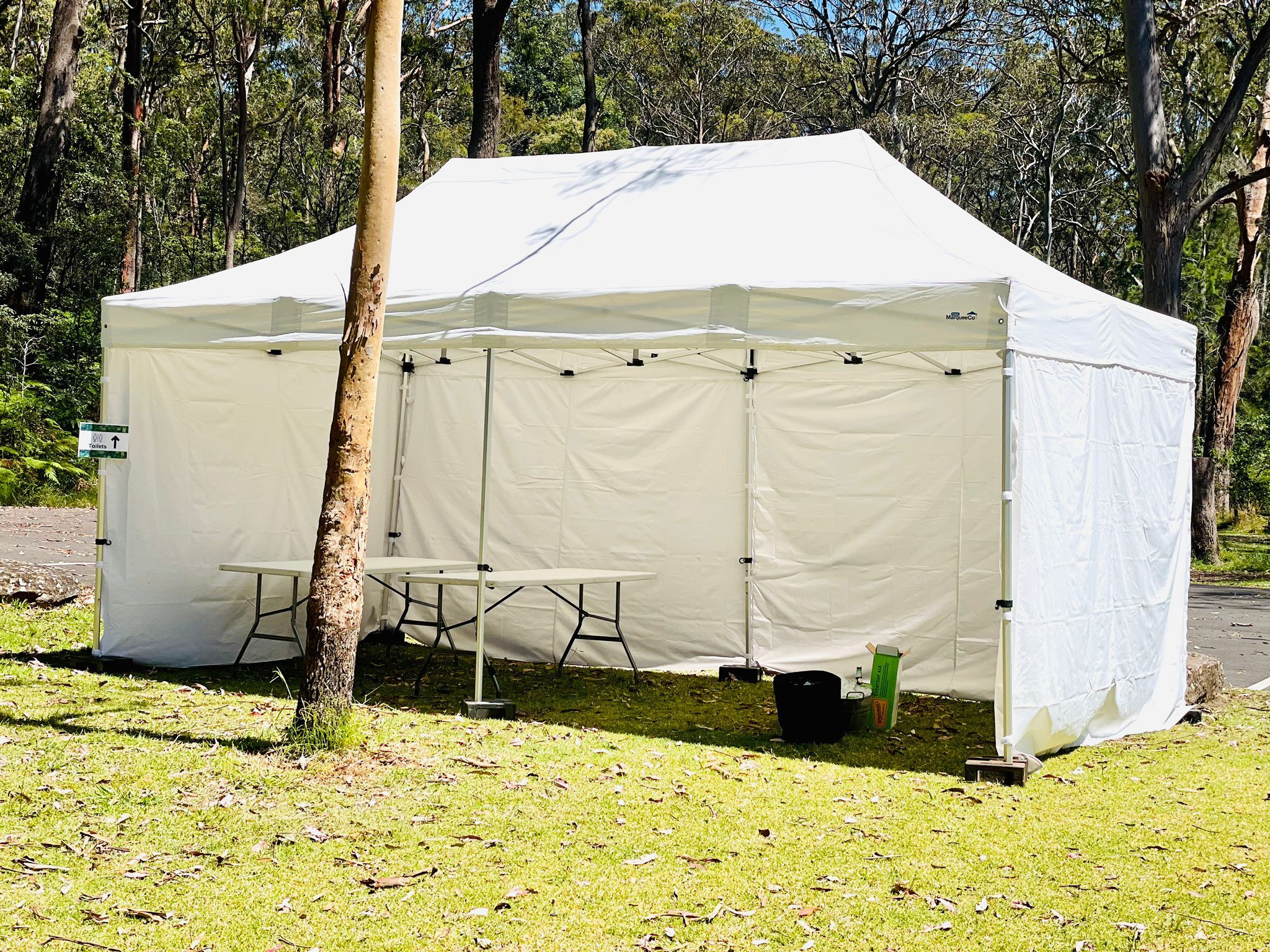 A 4mx8m pop-up marquee with walls set up in a grassy area.