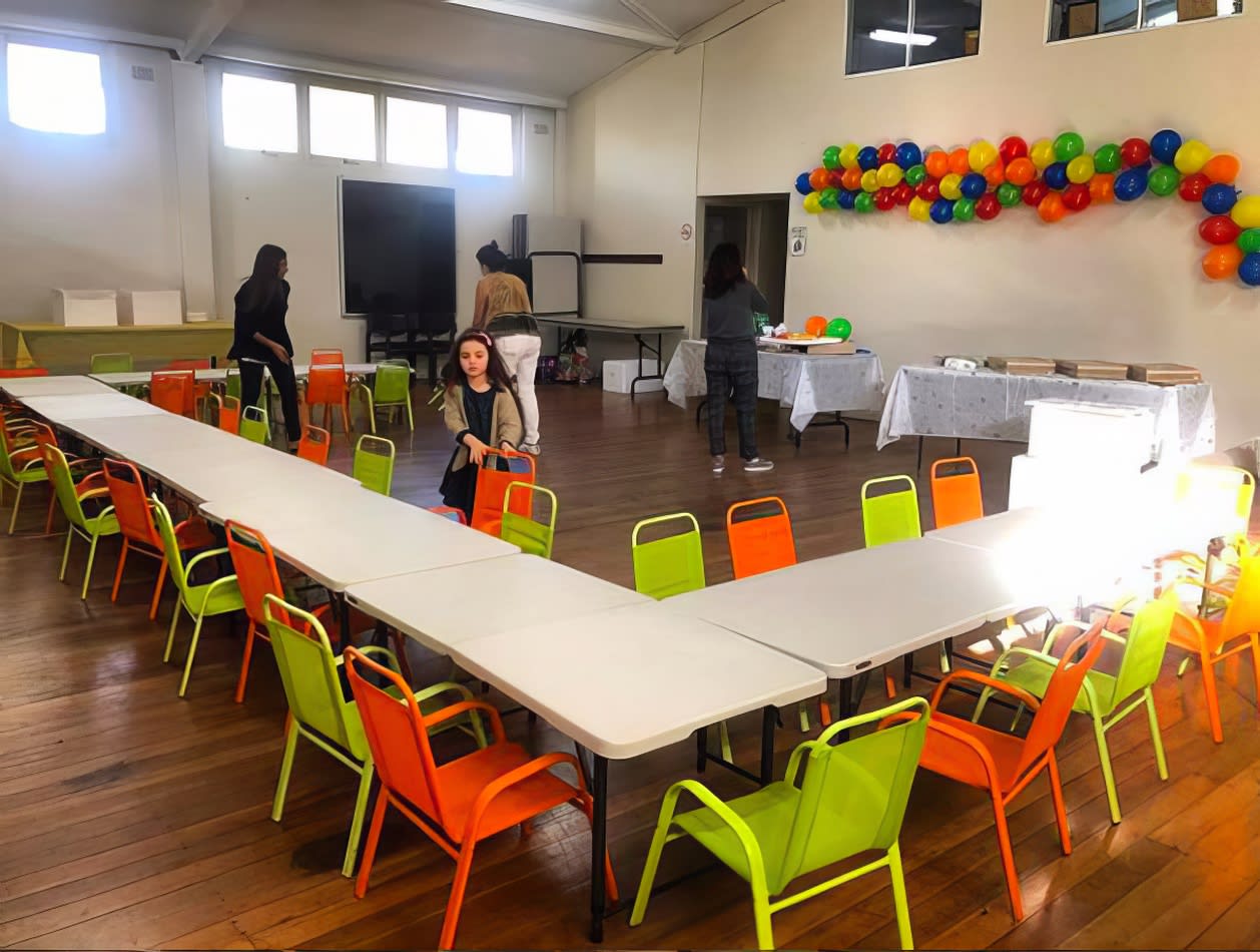 A whimsical room filled with colorful tables and chairs adorned with vibrant balloons.