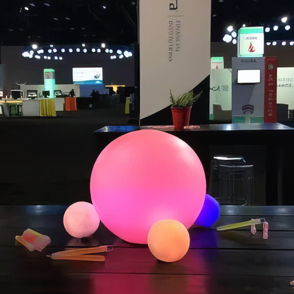 A vibrant ball sitting on a table at a convention, illuminated by a Glow Sphere.