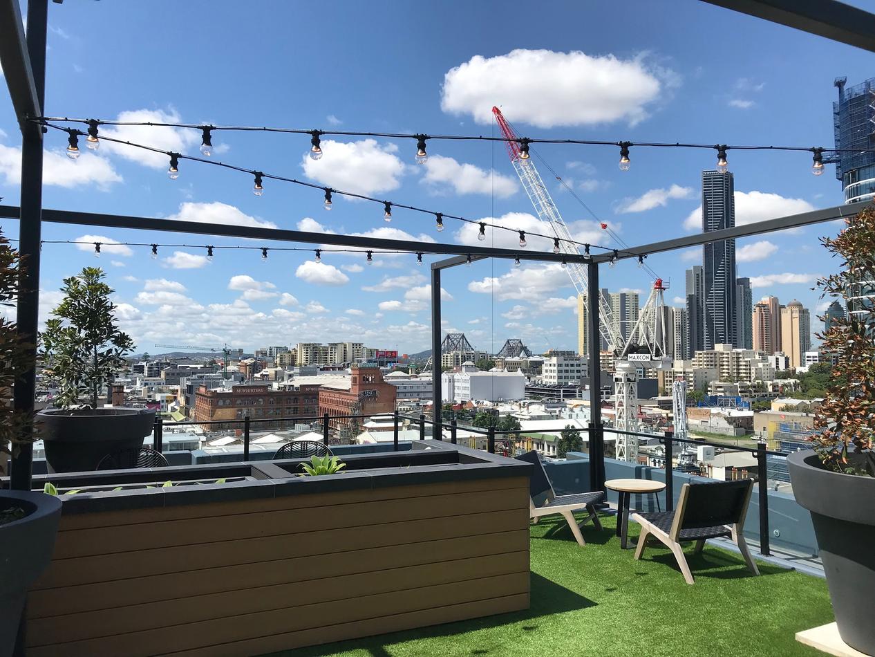 A rooftop deck adorned with festoon lights, providing a stunning view of the city.