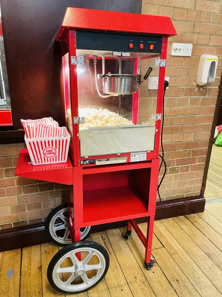 Red Popcorn Cart Hire sitting on a brick floor.