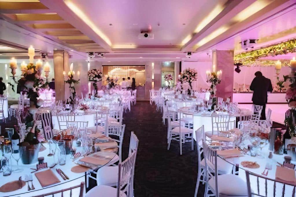 A large room with tables and Tiffany chairs set up for a christmas party.