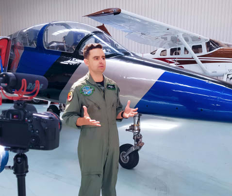 Afterburner team member talking in front of a jet plane