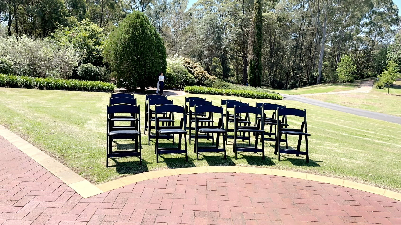 A group of Black Padded Folding Chairs set up in a park for hire.