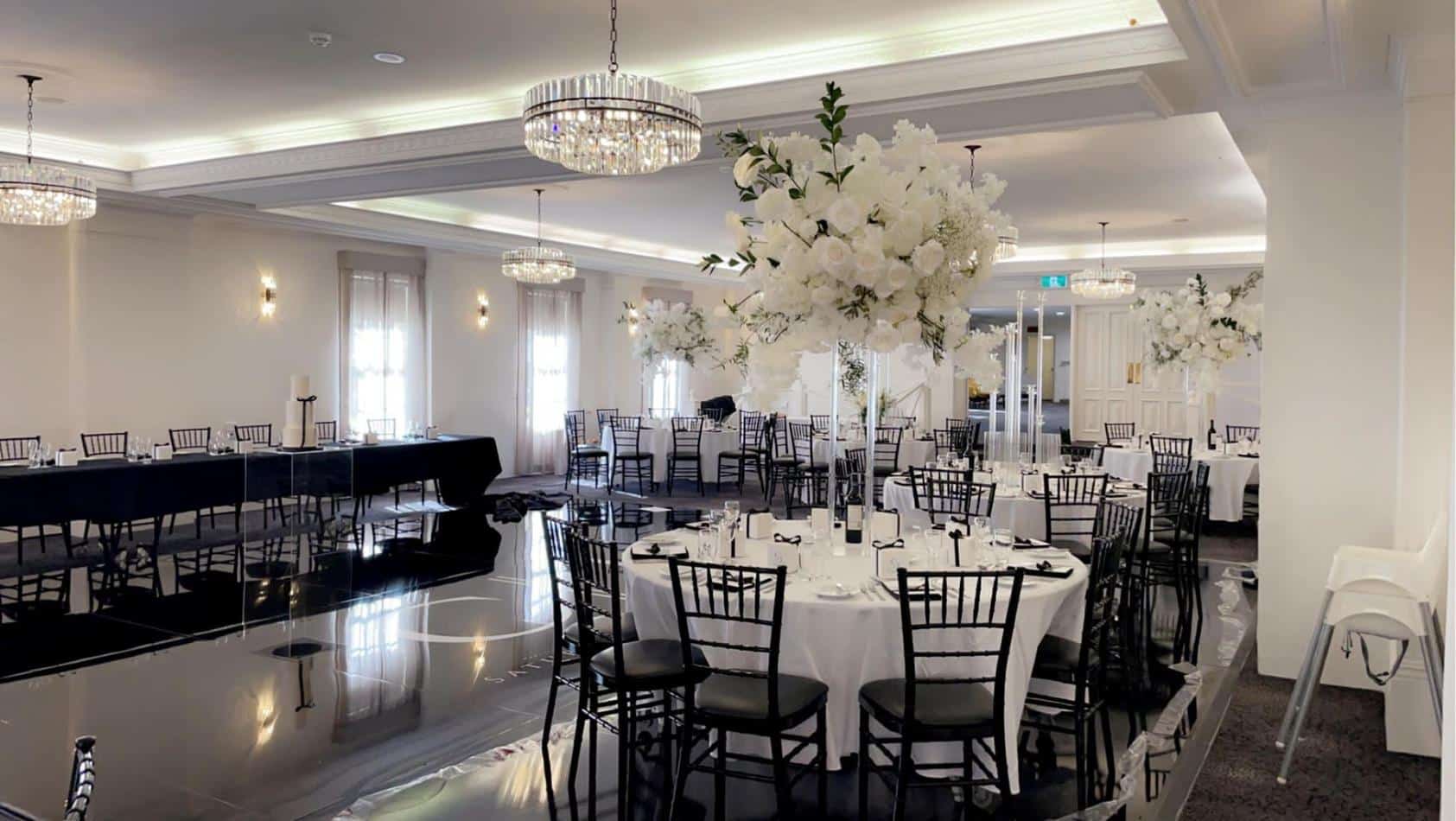 A black and white room with black Tiffany chair hire available for tables and chairs.