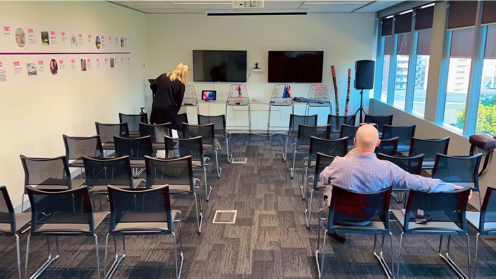 A group of people in conference chairs in a conference room.