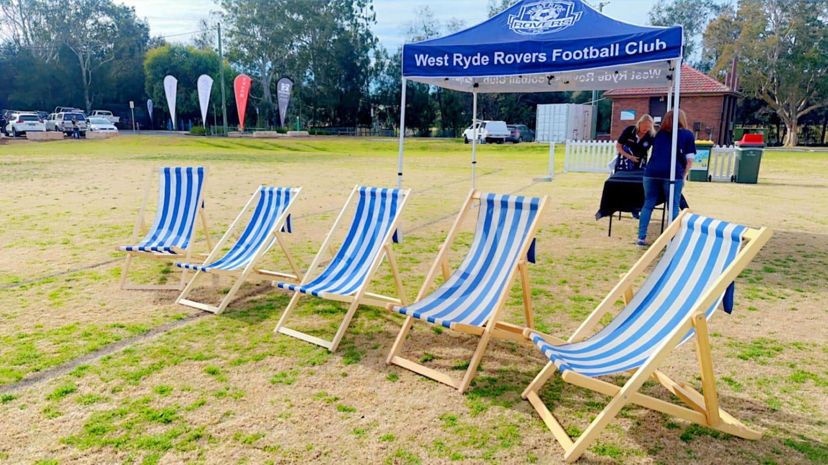 A group of blue and white deck chairs under a tent.