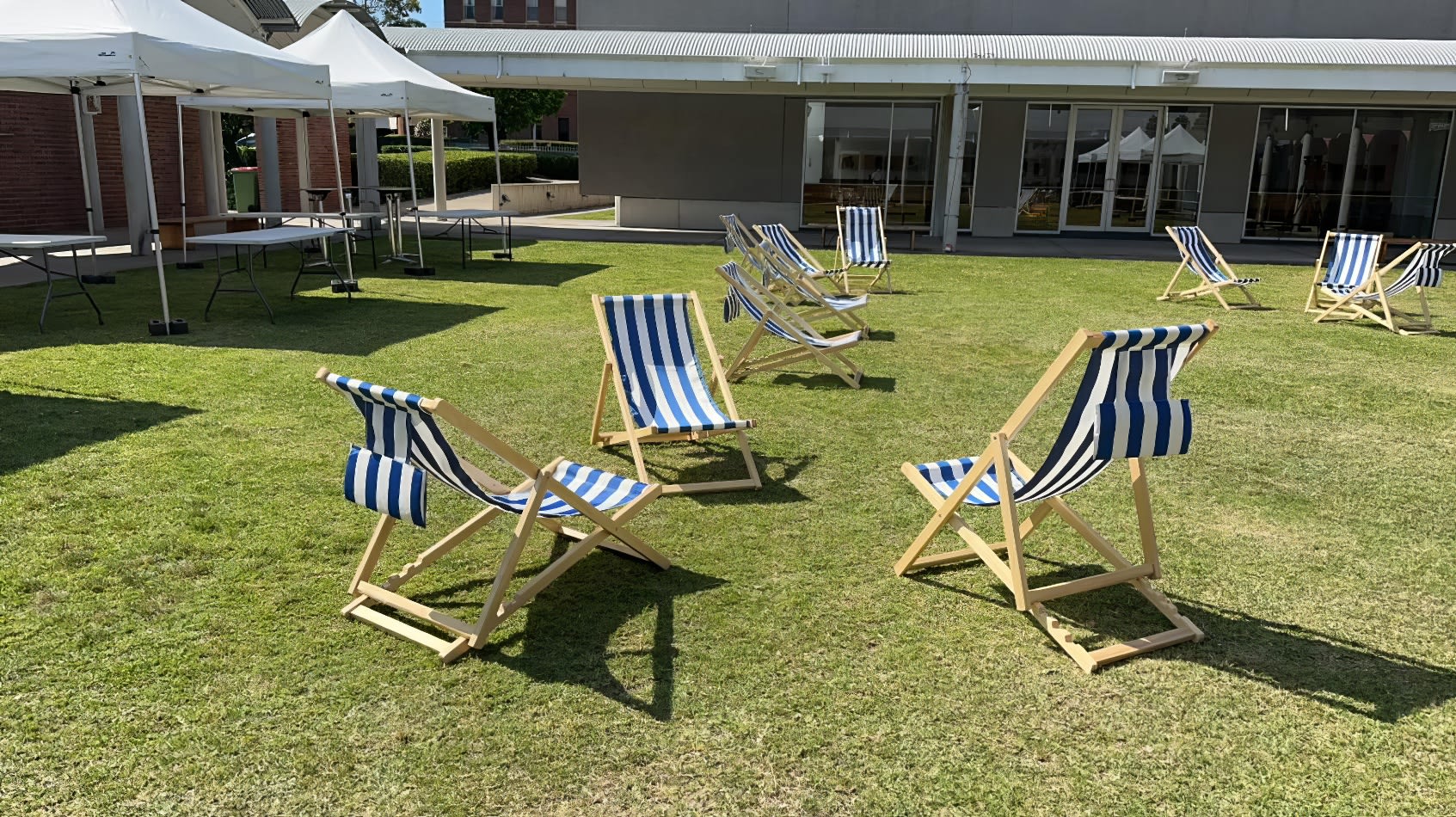 Deck chair hire: A row of blue and white deck chairs on a grassy area available for hire.