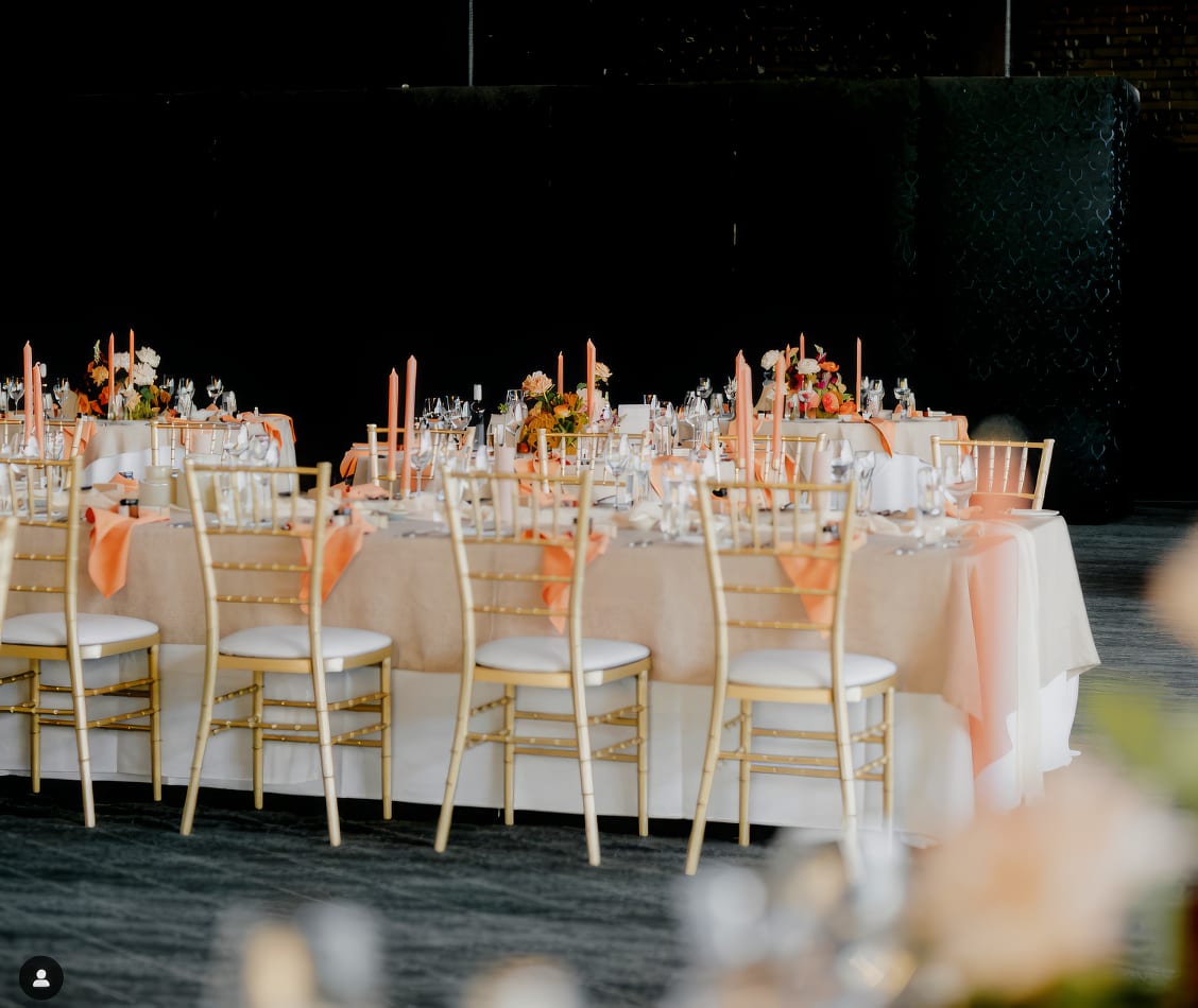 A wedding reception with gold tables and chairs.