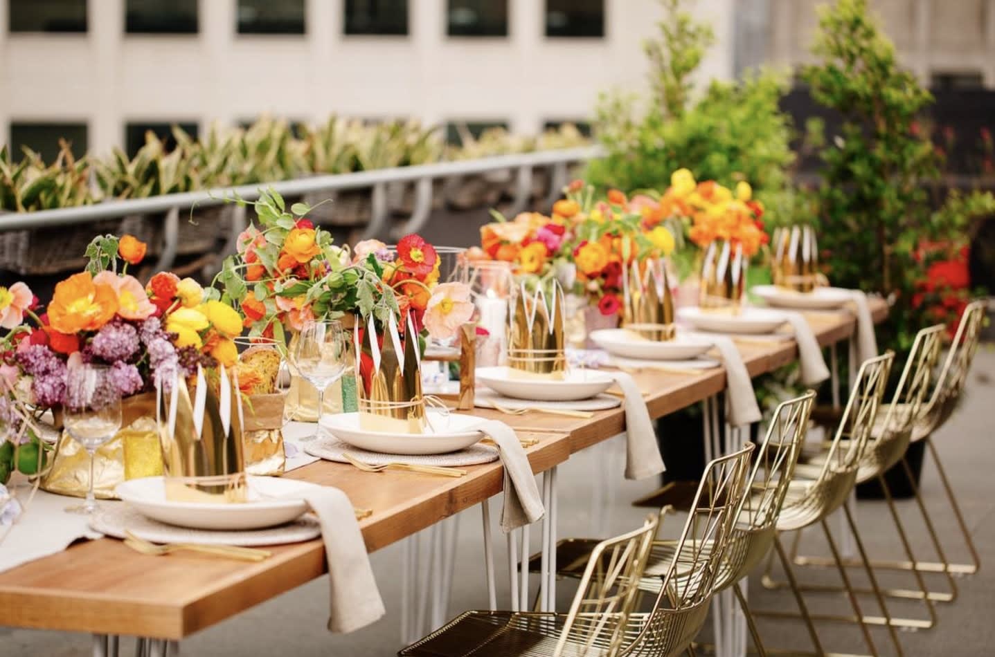 A table set with gold flowers on a rooftop.