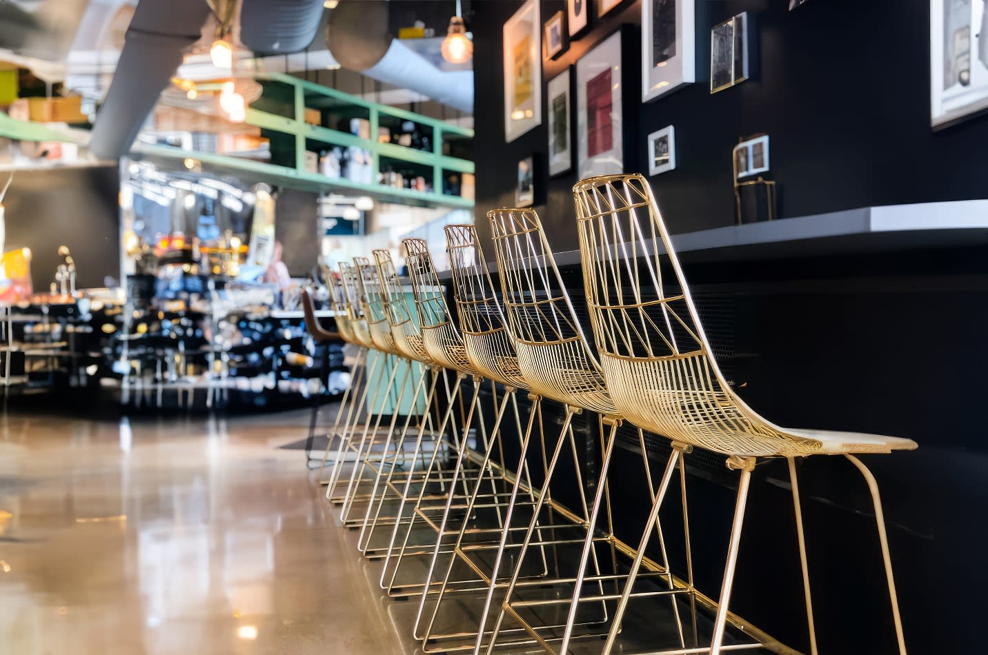 A row of gold bar stools in a restaurant, available for Gold Wire Stool hire.