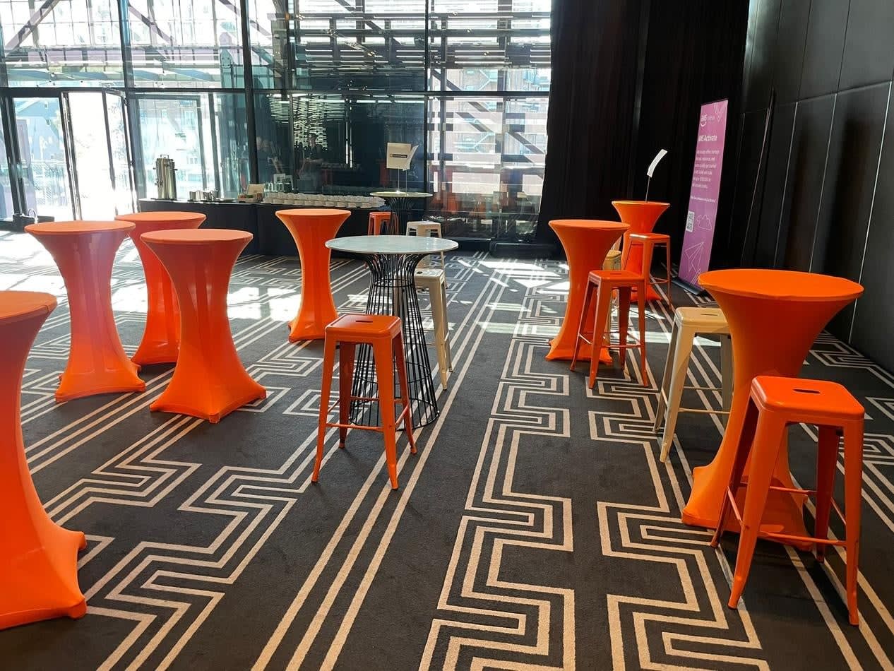 Orange Tolix stools and tables in a lobby.