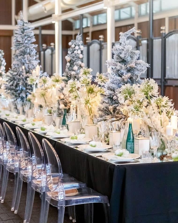 A Victorian-themed table set up for a Christmas party, complete with elegant ghost chairs.