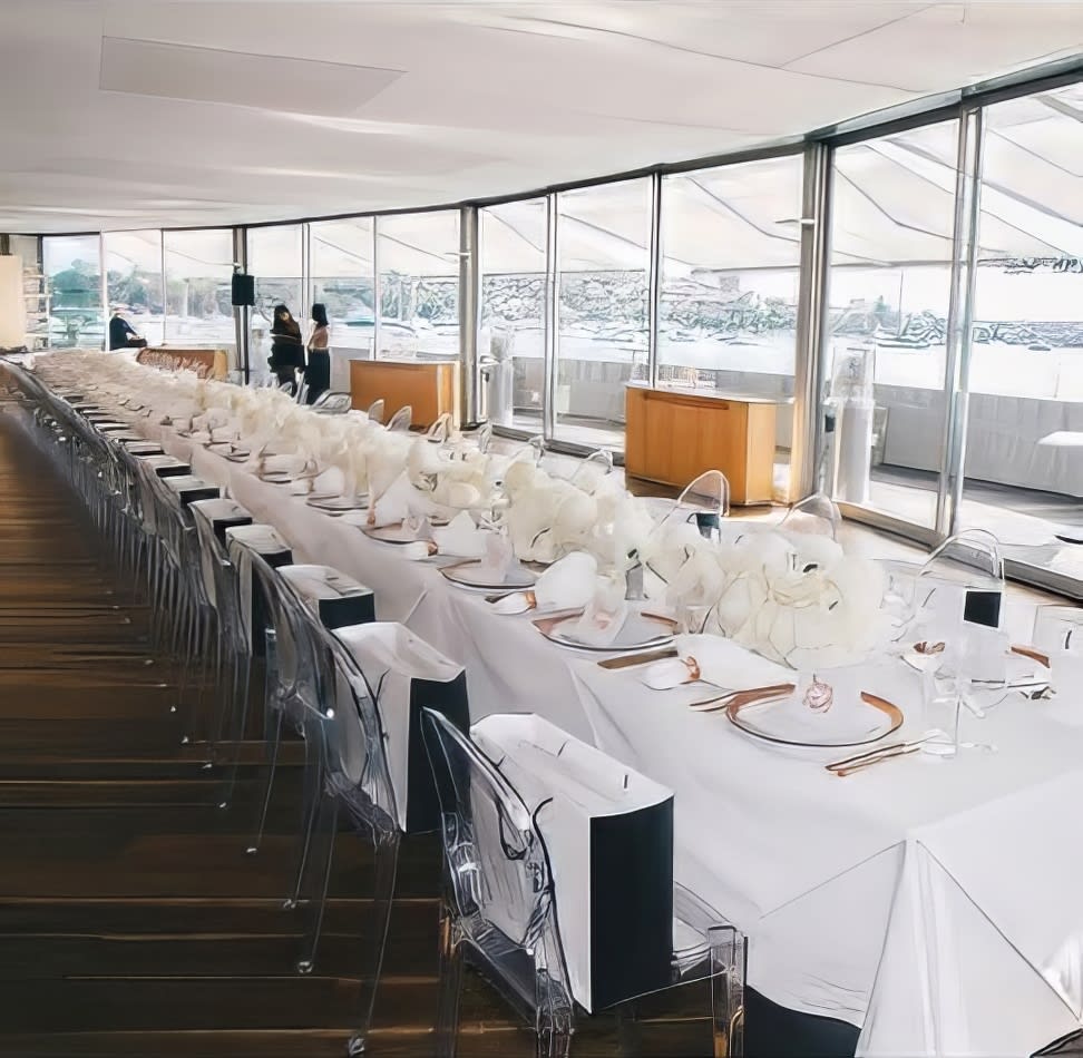 A long table set up with white Victorian ghost chairs.