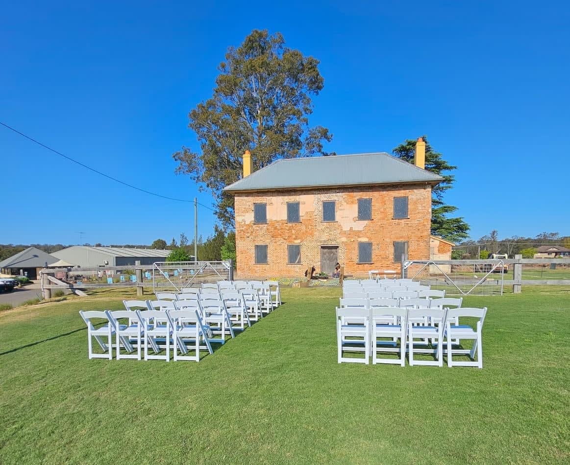 A wedding ceremony set up in front of a pristine white brick building.