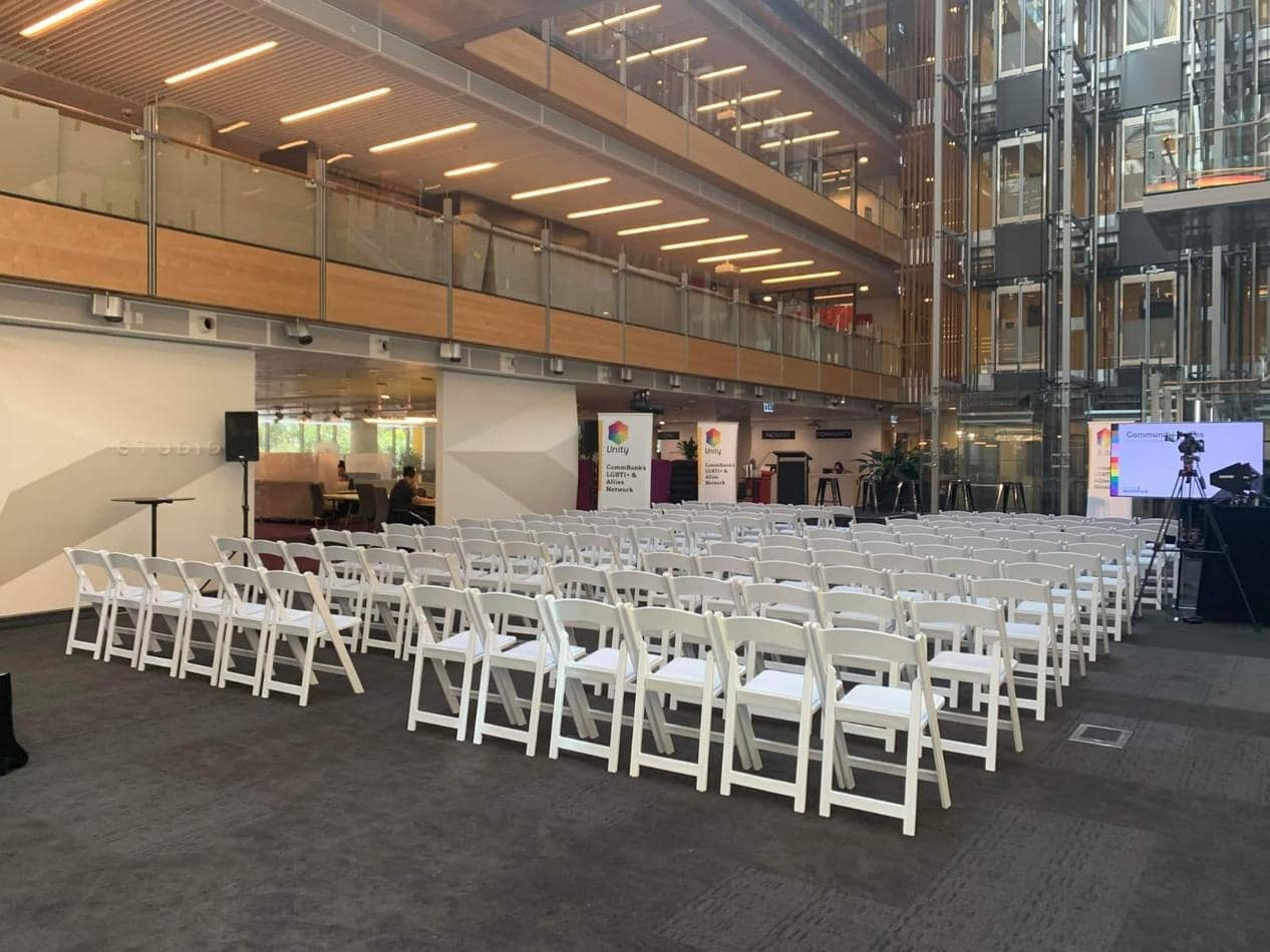 A large conference room with white Gladiator chairs and a large screen.