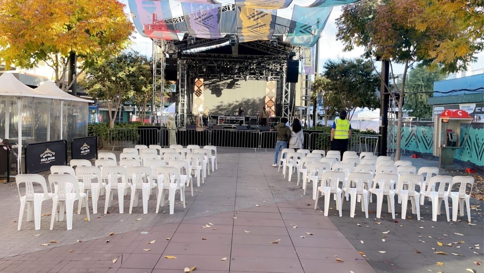 A stage set up with white plastic stackable chairs and banners.