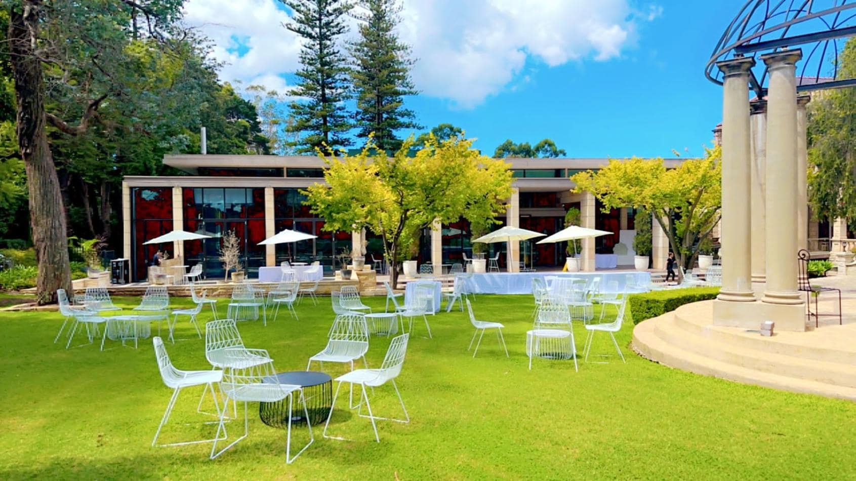 A large lawn with white tables and chairs available for White Chair Hire.