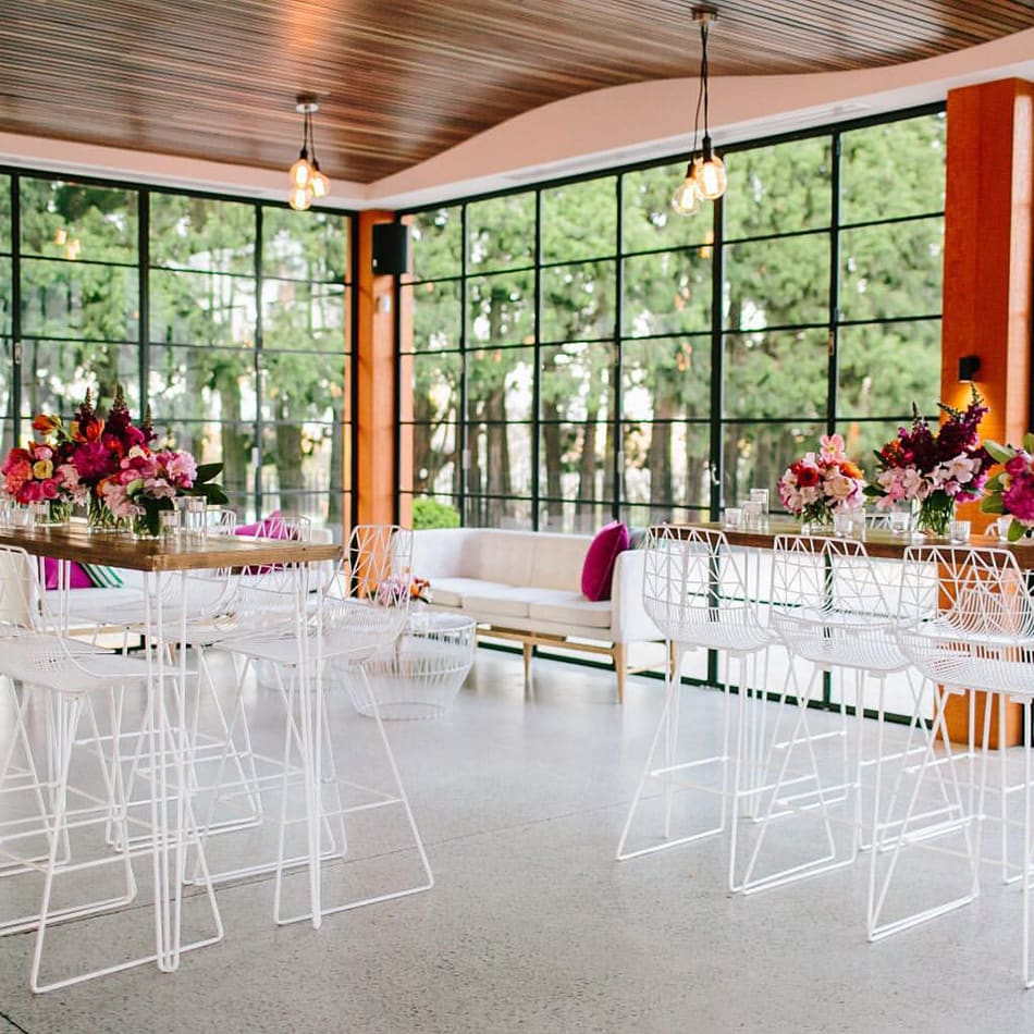 A room with white tables and chairs.