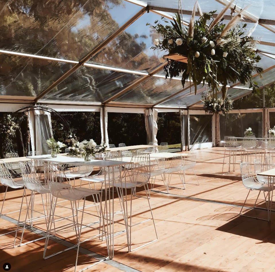 A white tent with tables and chairs in it, available for White Stool Hire.