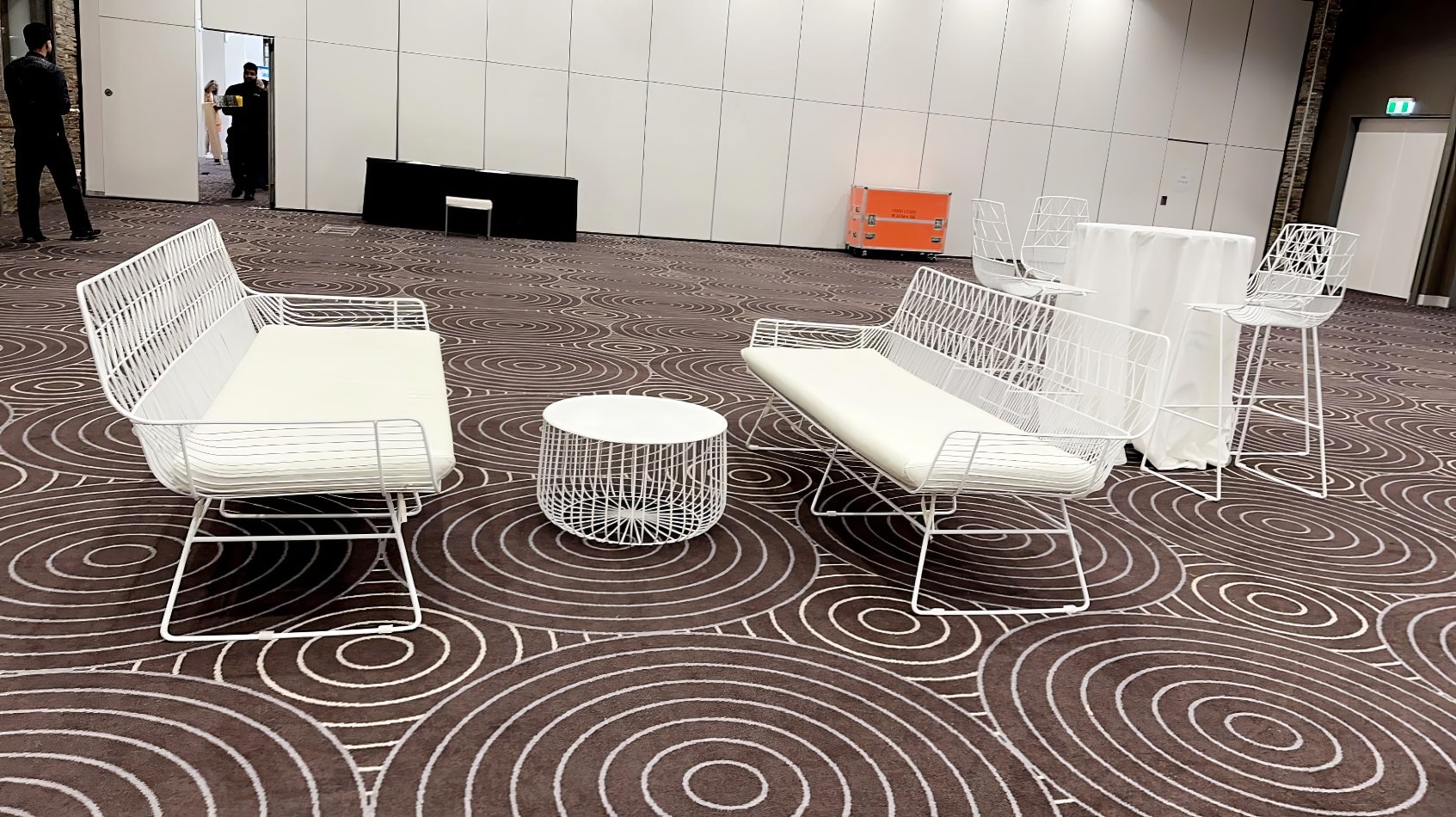 A white table and chairs in a room with a circular pattern.