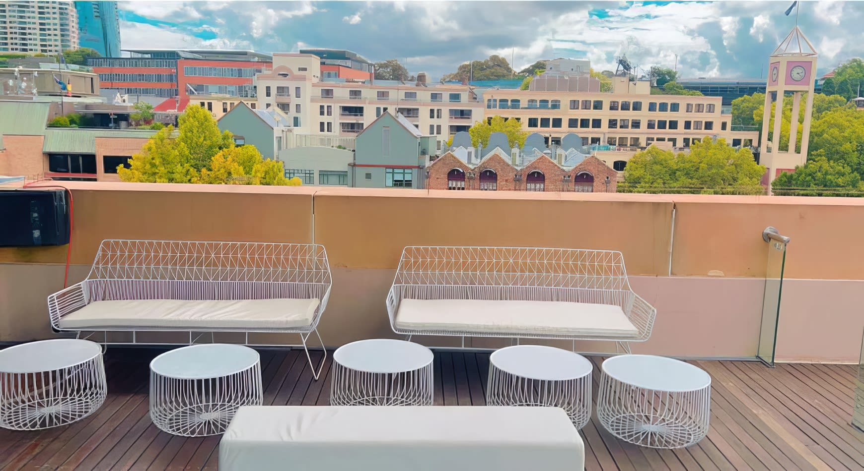 A breathtaking view of the city from the rooftop of a hotel, with a white arrow lounge seating arrangement for hire.