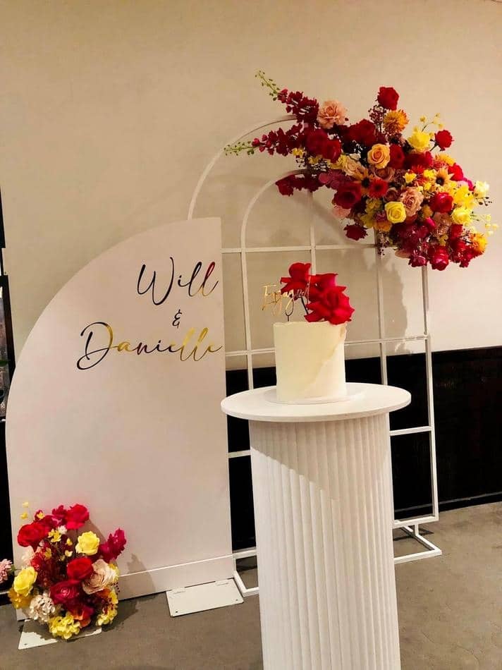 A table with flowers and a sign that says will and danielle.