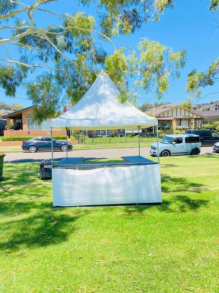 A fete stall/tent hire (including setup) in a grassy area.