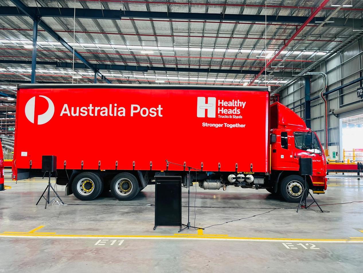 An Australian post truck is parked in a warehouse available for Lectern Hire.