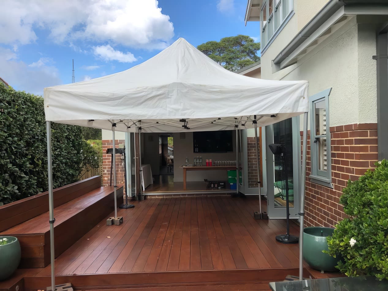 A 3mx6m pop up marquee with a white roof set up on a wooden deck.