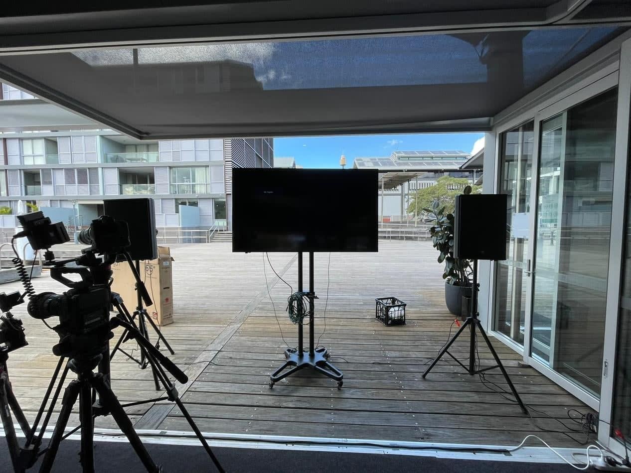 A speaker hire set up for a video shoot with a TV and tripods.