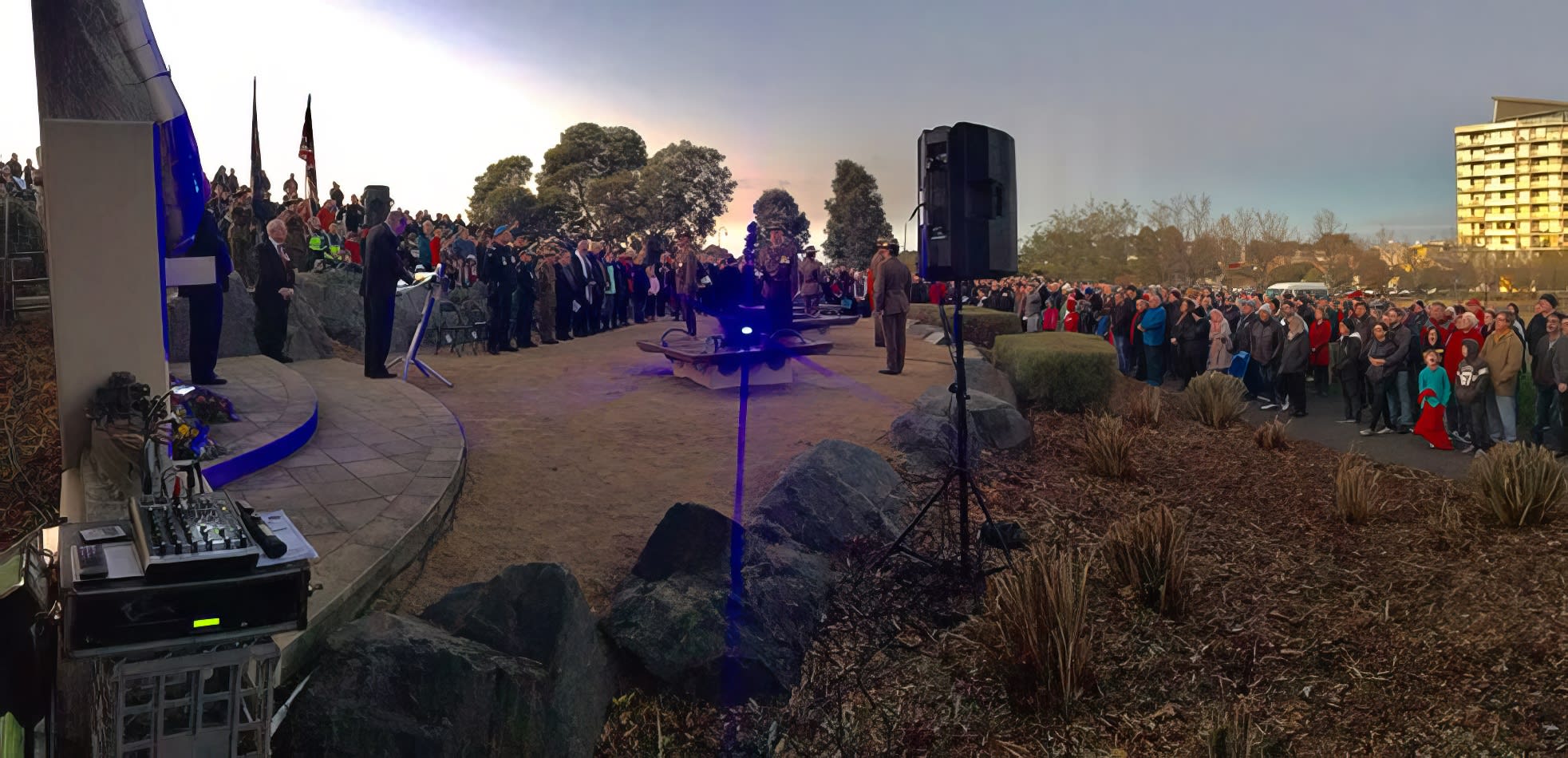 A crowd of people standing in front of a building, gathered for a Speaker Hire event.