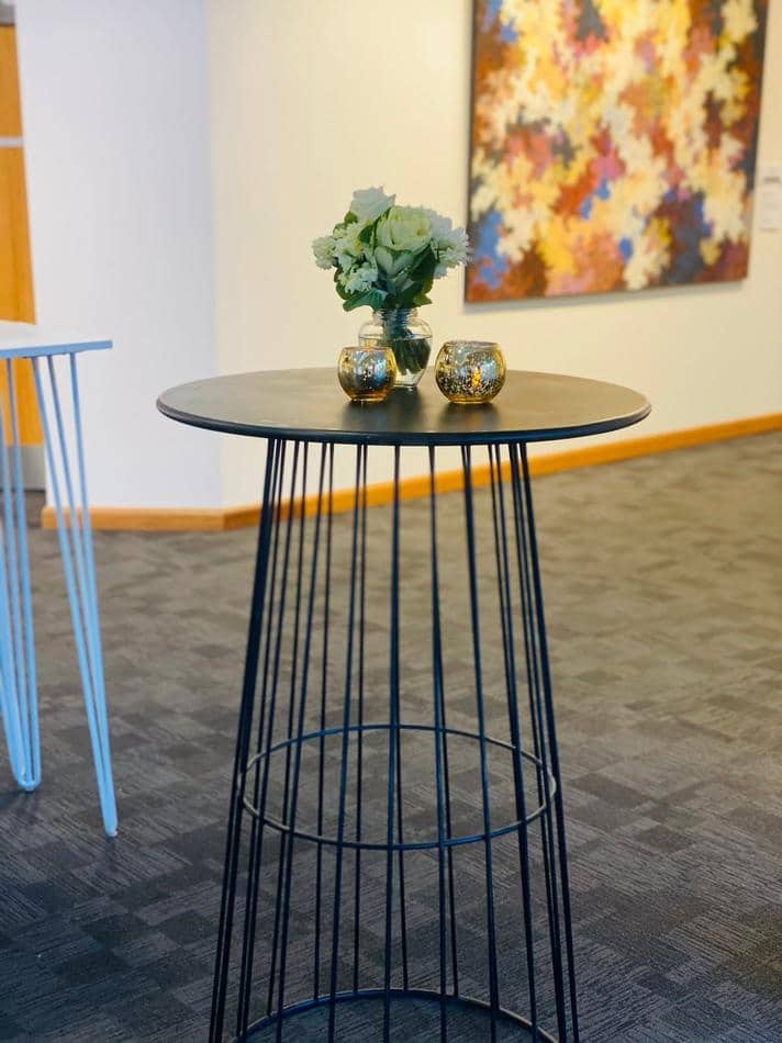 A black metal table with flowers on it.