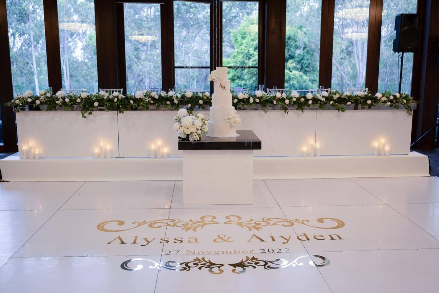 A wedding reception with a gloss cake on the table.