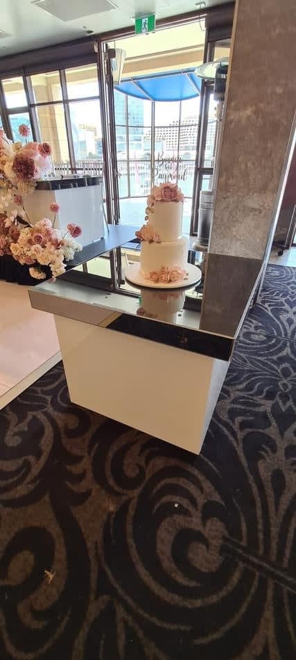 A glossy cake on top of a hire table.