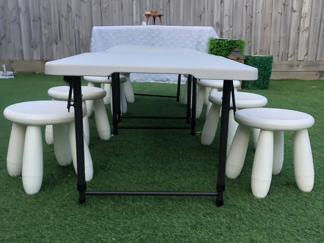 Kids Table Hire: A white table and stools set up in a grassy area.