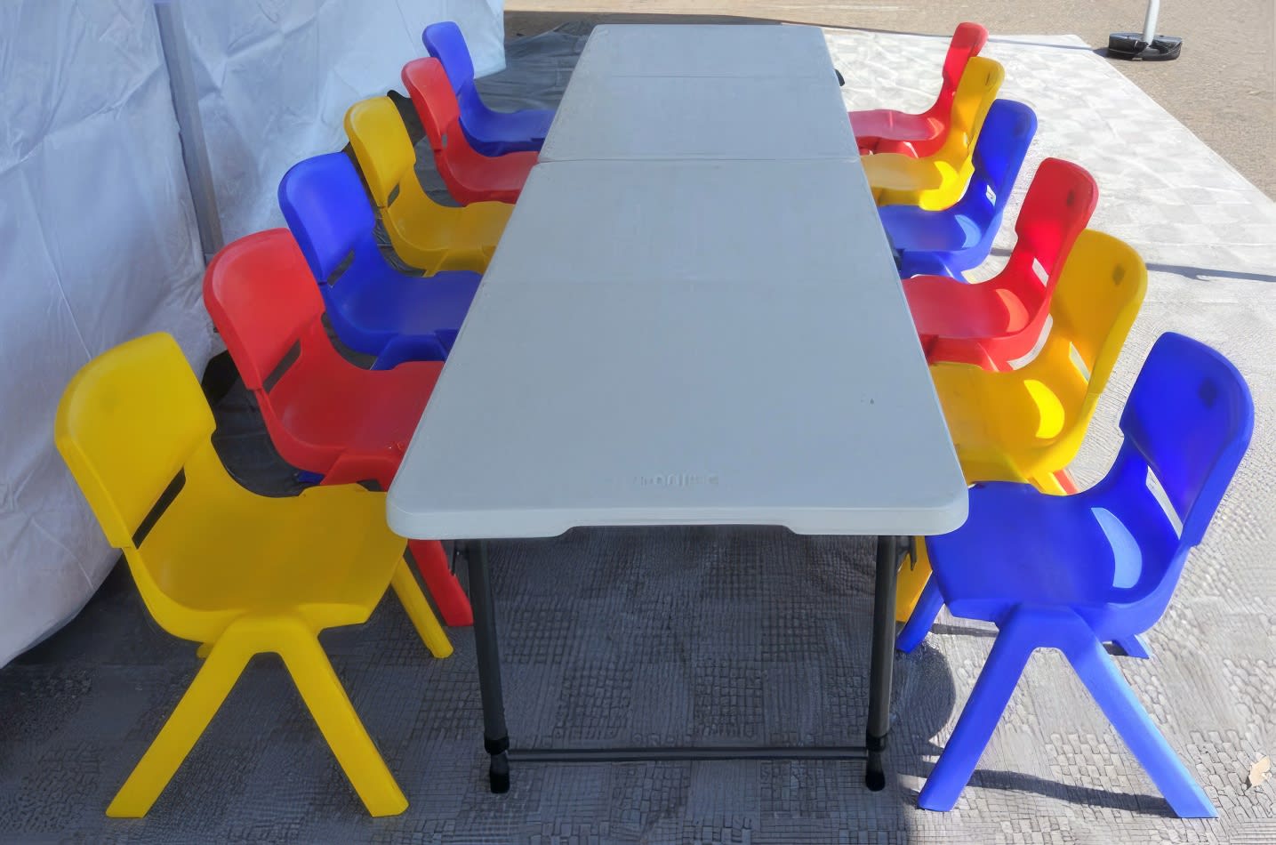 Kids Table Hire with a set of plastic chairs and a table in a tent.