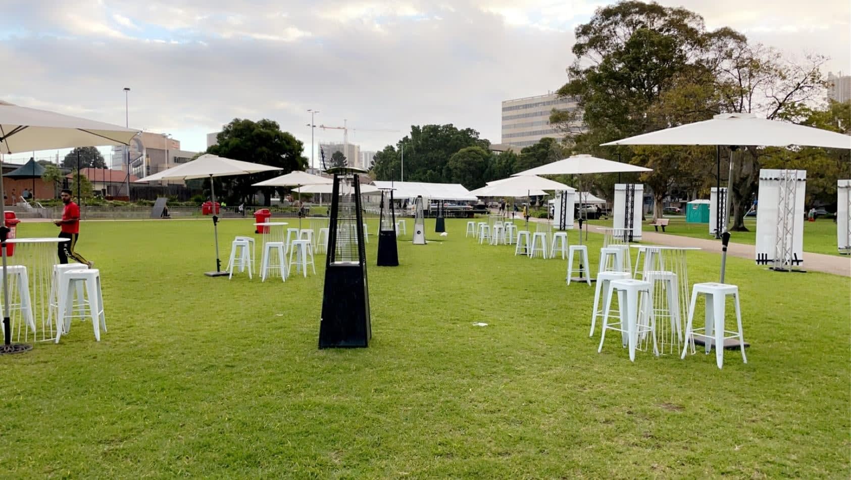 A group of tables and chairs set up on a grassy area, available for Market Umbrella Hire.