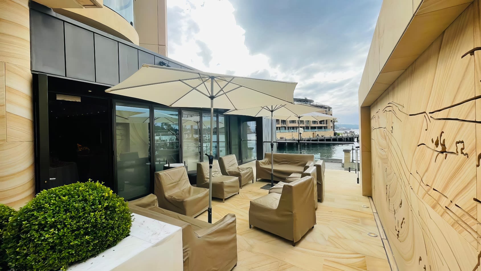 A balcony with lounge chairs and umbrellas overlooking the water, perfect for Market Umbrella Hire.