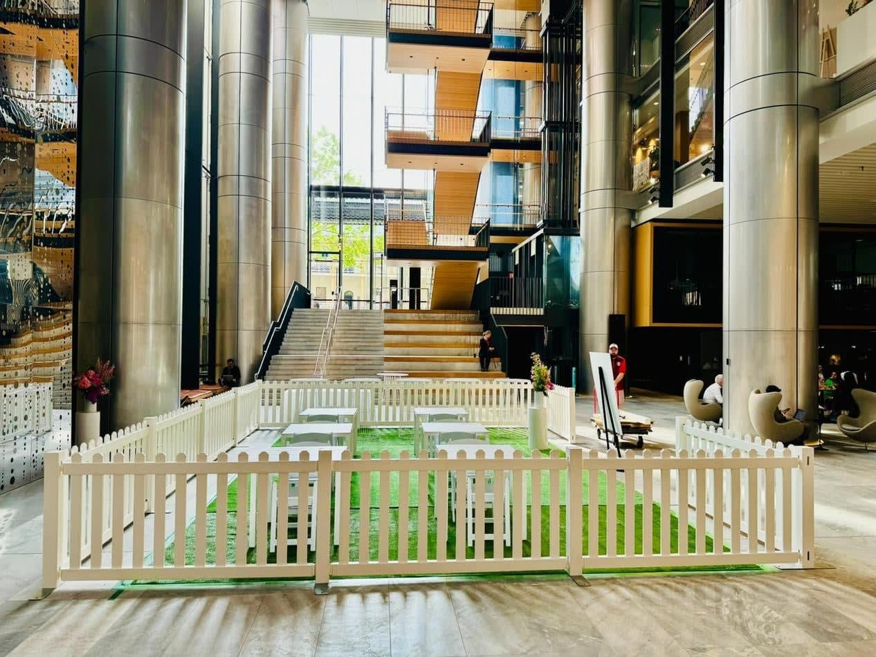 An office building lobby featuring a white picket fence as captivating decor.