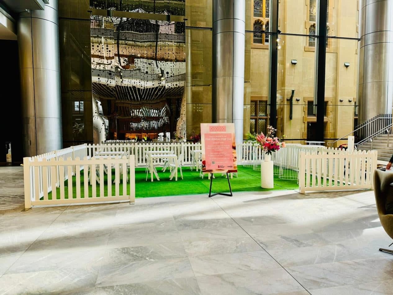 A lobby with a white picket fence and green grass.