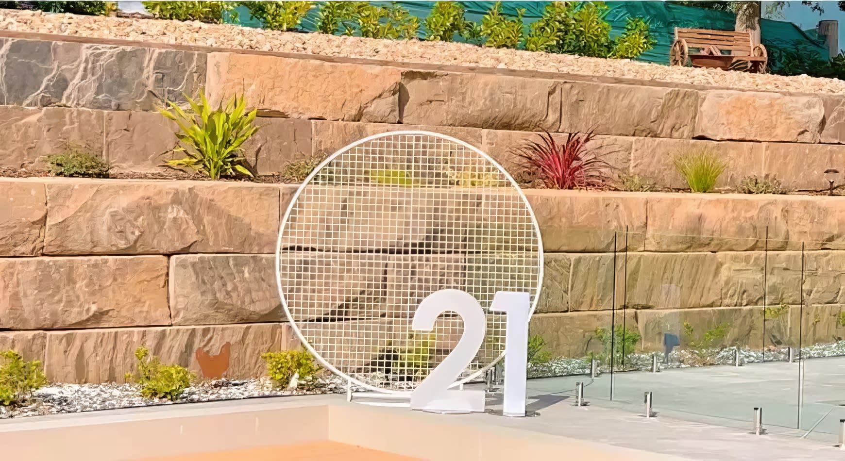 A circular white mesh backdrop is set up in front of a swimming pool.