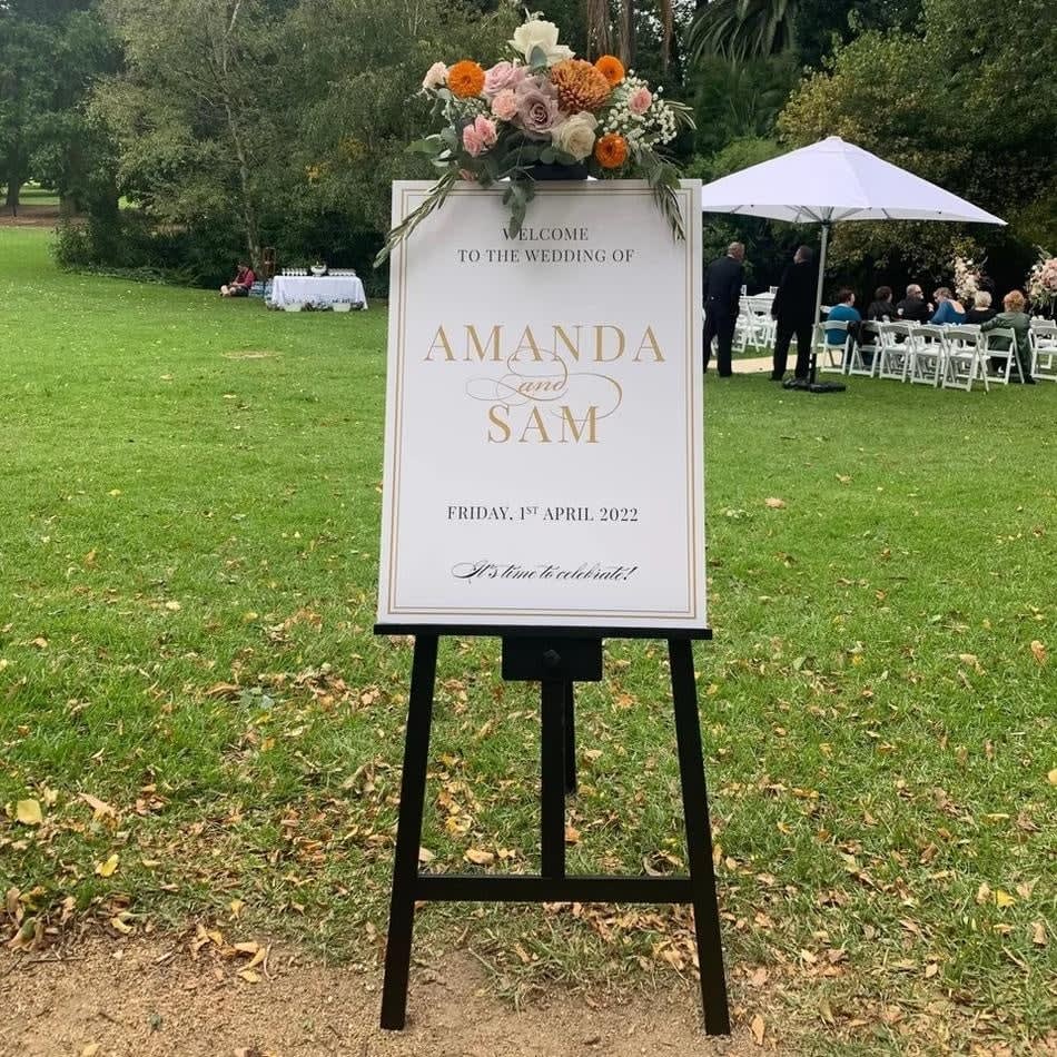 Amanda and Sam's wedding sign displayed on a black wooden easel.