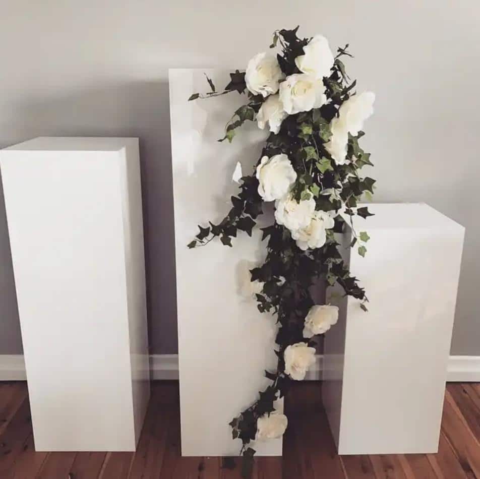 Three large white pillars adorned with flowers.