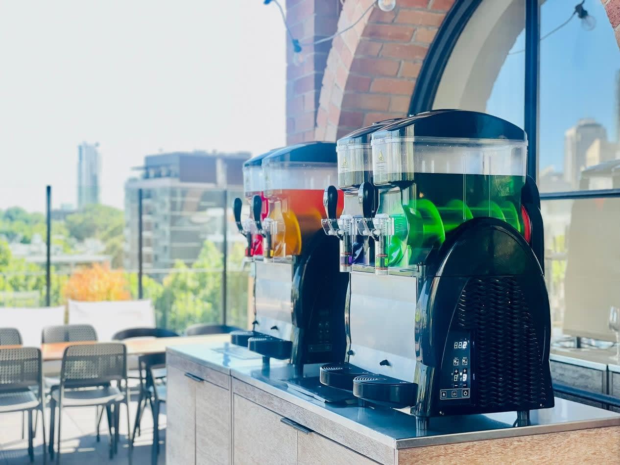 Two Slushie machines on a balcony with a view of the city serving an abundant package of 120 drinks.