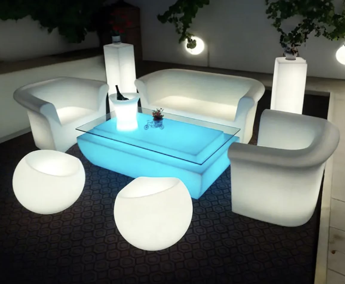 A living room with a white double seater sofa, chairs, and a glow lamp.